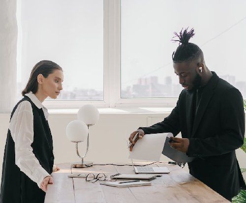 Two people working either side of a table, with a distant view of a city in the background.